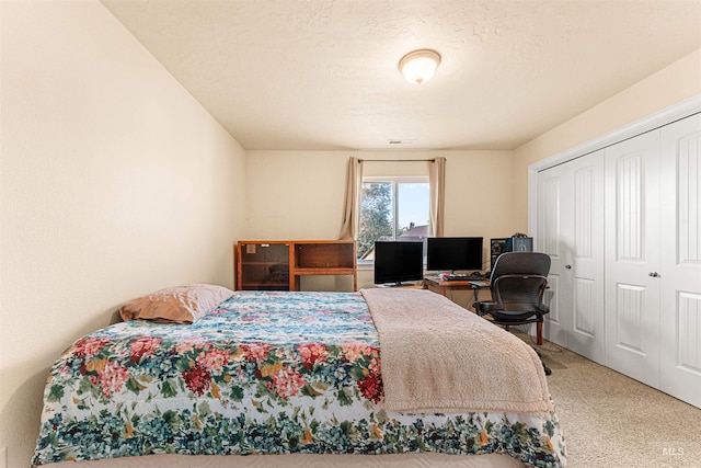 bedroom with carpet flooring, an office area, and a closet