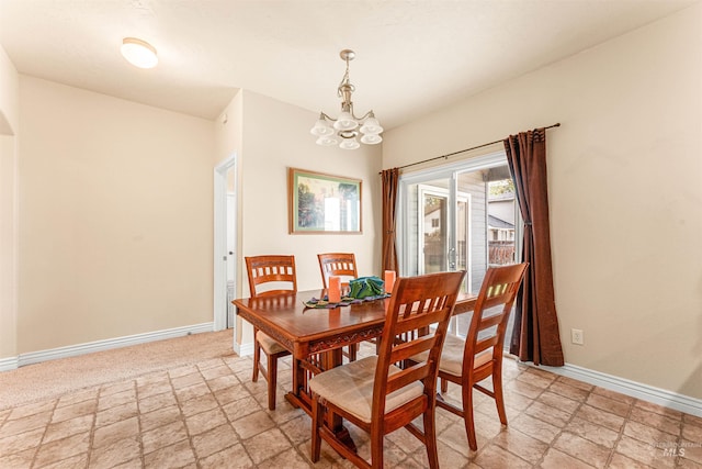 dining space with a chandelier, baseboards, and light stone finish flooring
