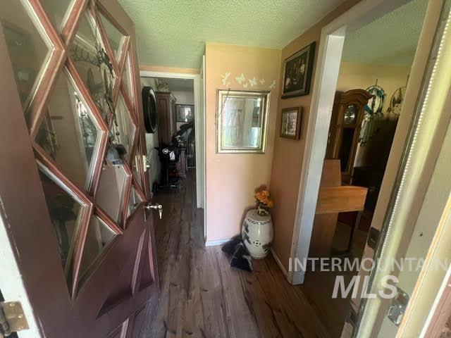 corridor featuring a textured ceiling and dark hardwood / wood-style floors