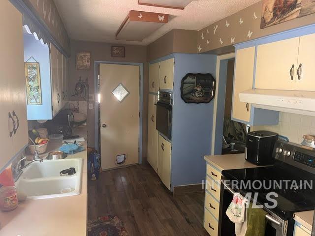 kitchen featuring oven, white cabinetry, exhaust hood, stainless steel range with electric cooktop, and dark hardwood / wood-style flooring