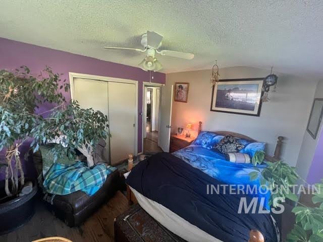 bedroom featuring a closet, ceiling fan, hardwood / wood-style floors, and a textured ceiling