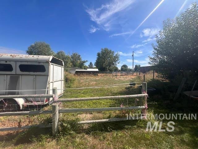 view of yard with a shed and a rural view