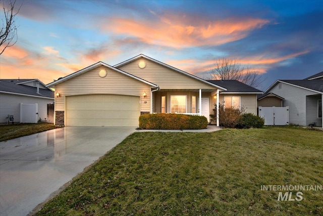 ranch-style house with a front yard, a gate, fence, driveway, and a garage