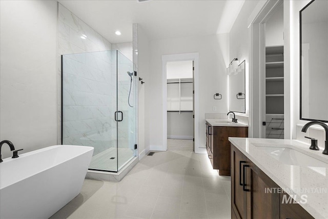 bathroom featuring tile patterned flooring, shower with separate bathtub, and vanity