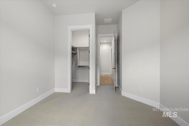 unfurnished bedroom with light carpet and a closet