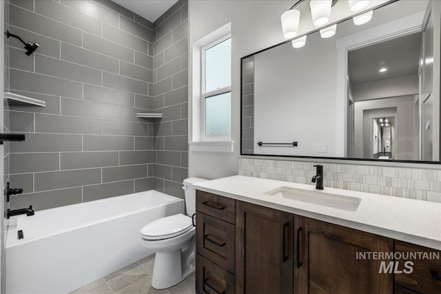 full bathroom with tile patterned flooring, toilet, decorative backsplash, vanity, and tiled shower / bath