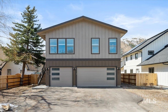 701 N 2nd Ave, Hailey, ID 83333 - view of front of house with fence, an attached garage, board and batten siding, a mountain view, and driveway