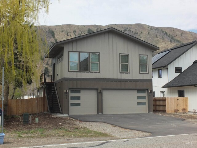 701 N 2nd Ave, Hailey, ID 83333 - view of front of house with an attached garage, fence, a mountain view, and aphalt driveway