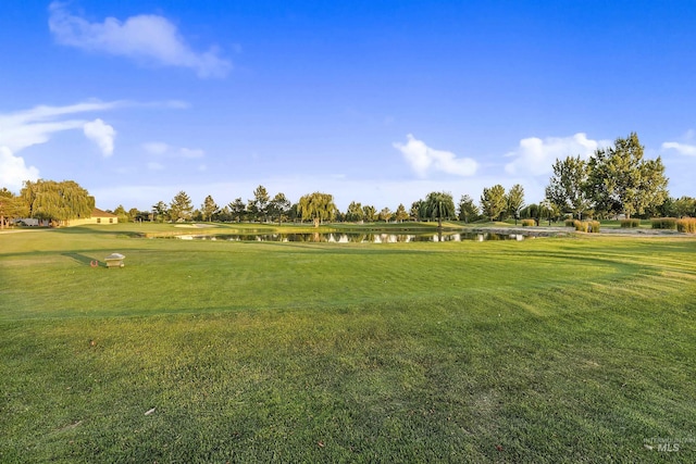 surrounding community featuring a lawn and a water view