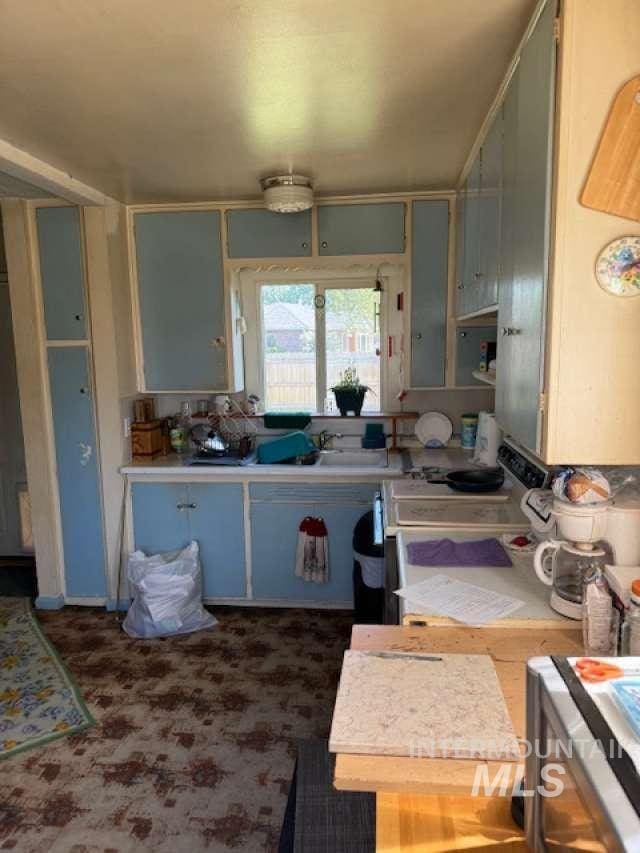 225 E Melrose St, Boise, ID 83706 - kitchen featuring light countertops, range with electric stovetop, and dark carpet