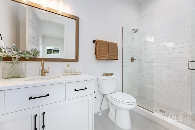 bathroom featuring toilet, tile patterned floors, walk in shower, and vanity