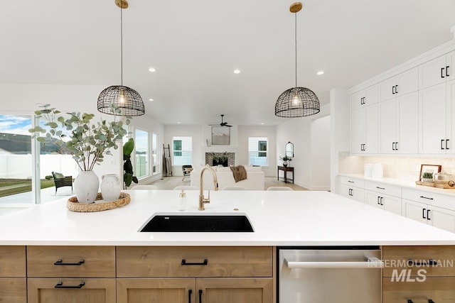 kitchen featuring decorative light fixtures, sink, white cabinets, and a center island