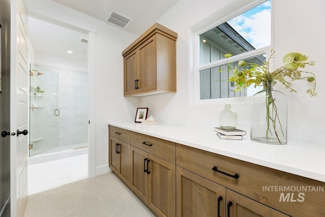 interior space with a shower with shower door and vanity