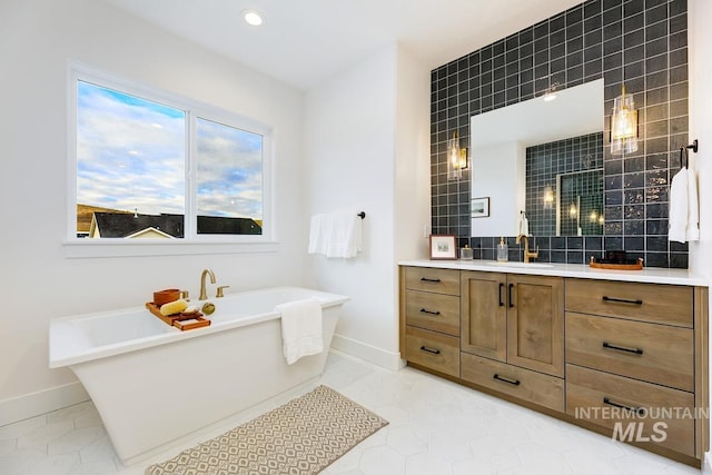 bathroom with tasteful backsplash, vanity, tile patterned floors, and a bathing tub