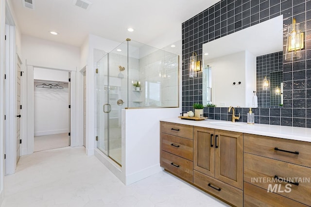 bathroom featuring a shower with shower door, backsplash, and vanity