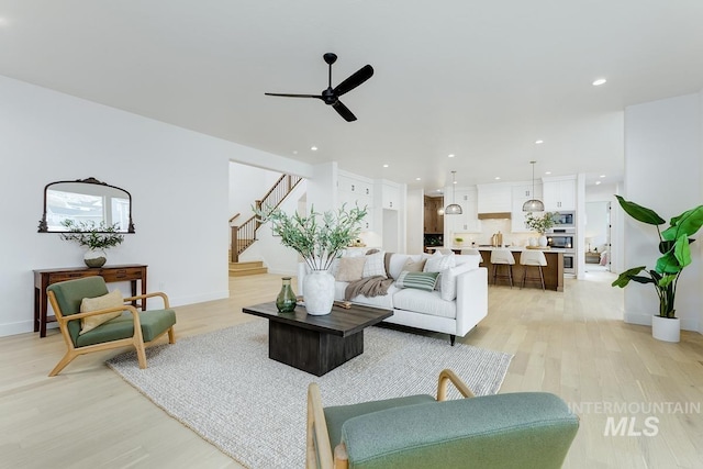 living room featuring ceiling fan and light wood-type flooring