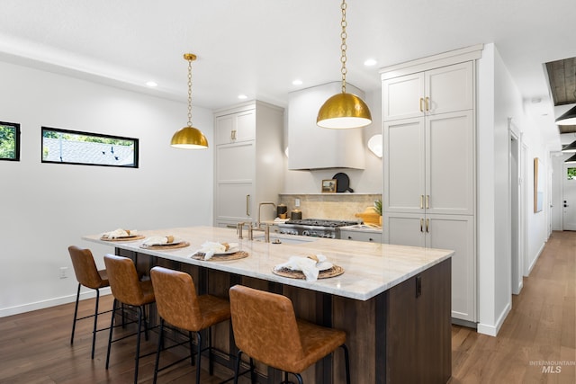 2206 N 20th, Boise, ID 83702 - kitchen featuring recessed lighting, dark wood-style flooring, a kitchen breakfast bar, and light stone countertops