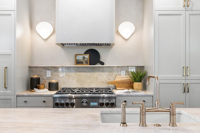 2206 N 20th, Boise, ID 83702 - kitchen featuring backsplash, white cabinetry, light stone countertops, and ventilation hood