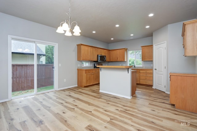 10224 W Altair, Star, ID 83669 - kitchen featuring stainless steel microwave, light countertops, light wood-style flooring, a chandelier, and a center island