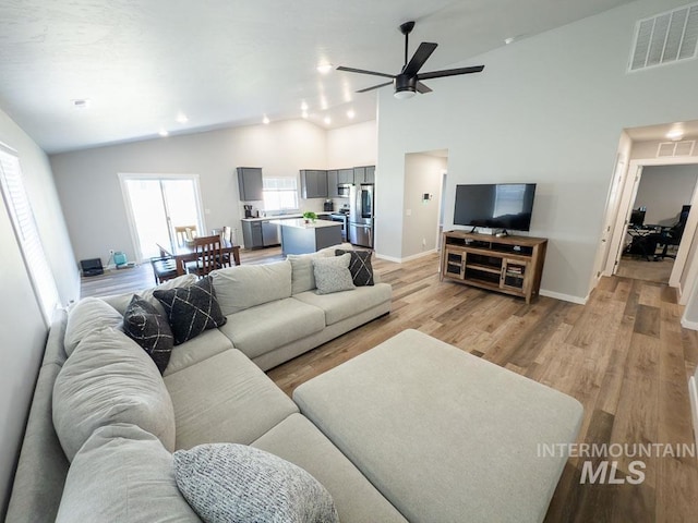 13743 S Sonata Way, Nampa, ID 83651 - living room featuring vaulted ceiling, light wood-type flooring, a ceiling fan, and baseboards
