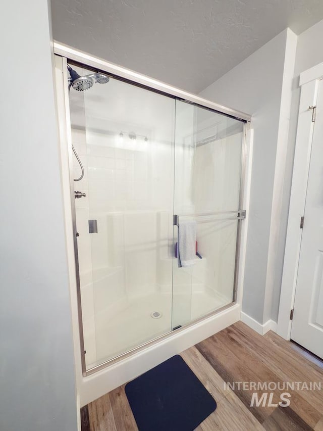 13743 S Sonata Way, Nampa, ID 83651 - full bath with wood finished floors, a shower stall, and baseboards