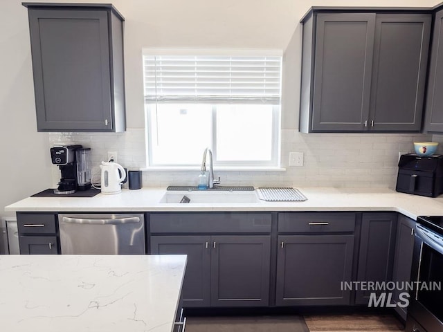 13743 S Sonata Way, Nampa, ID 83651 - kitchen featuring stainless steel dishwasher, decorative backsplash, a sink, light stone counters, and gray cabinetry