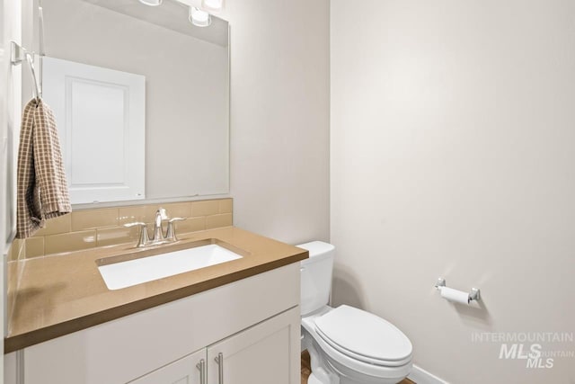 4672 N Patimos Ave, Meridian, ID 83646 - half bathroom with vanity, toilet, decorative backsplash, and baseboards