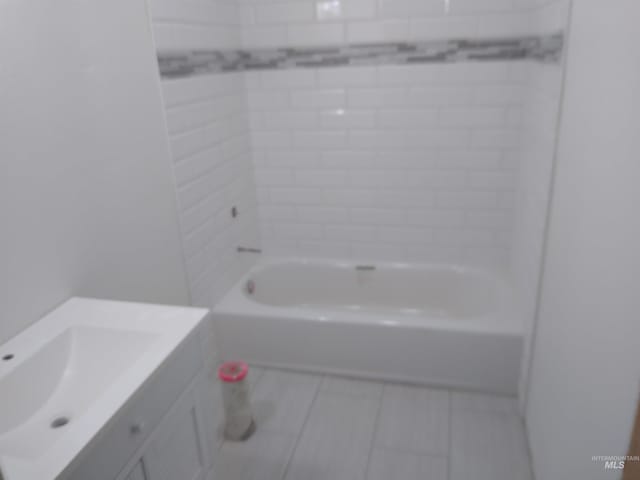 bathroom featuring vanity and tiled shower / bath