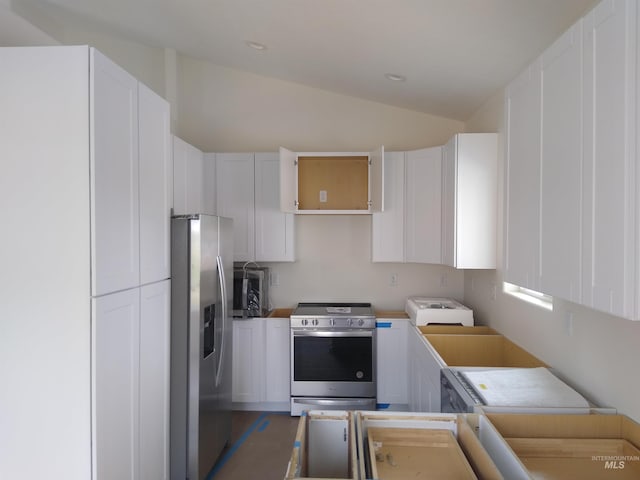 kitchen featuring white cabinetry, stainless steel appliances, and vaulted ceiling