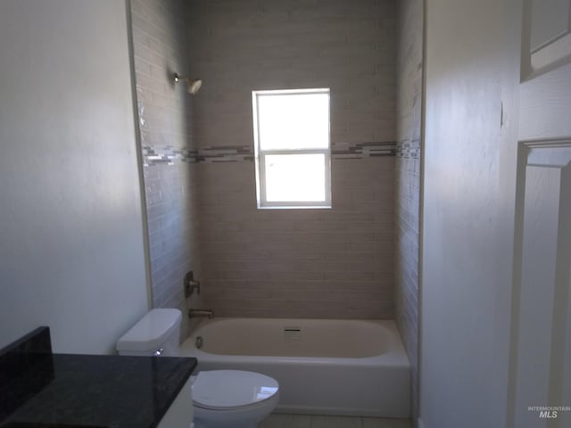 full bathroom featuring vanity, tiled shower / bath combo, and toilet