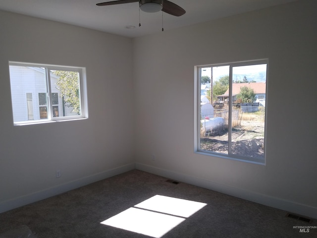 carpeted empty room featuring ceiling fan and a healthy amount of sunlight