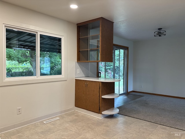 1715 S 10th Ave, Caldwell, ID 83605 - kitchen with light countertops, open shelves, light flooring, and brown cabinets