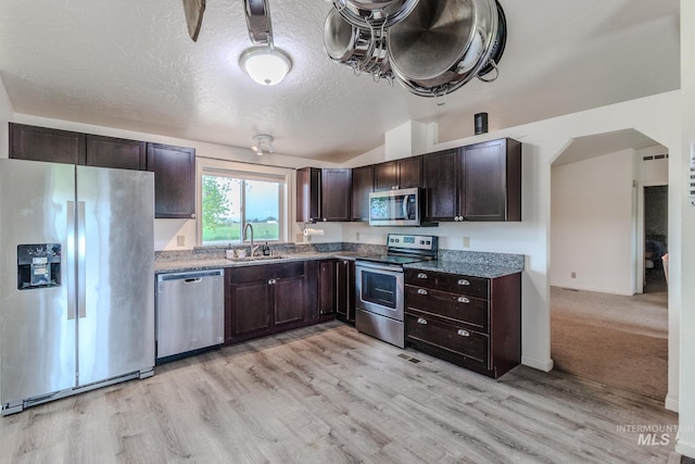 3537 Brogan Rd, Emmett, ID 83617 - kitchen with appliances with stainless steel finishes, a sink, dark brown cabinetry, light wood-type flooring, and a textured ceiling