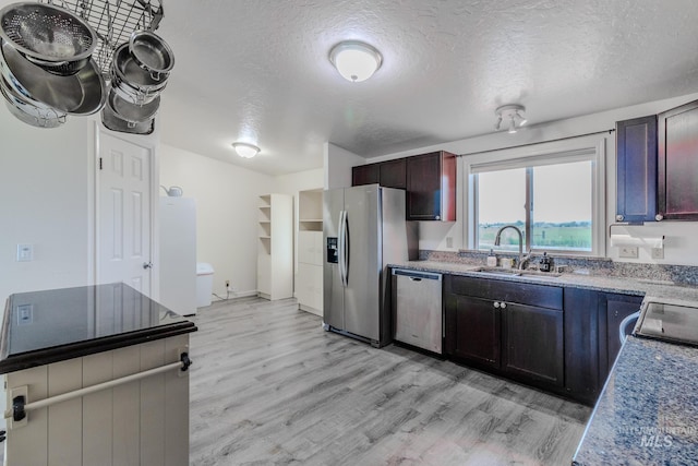 3537 Brogan Rd, Emmett, ID 83617 - kitchen with stainless steel appliances, a sink, light wood finished floors, a textured ceiling, and light countertops