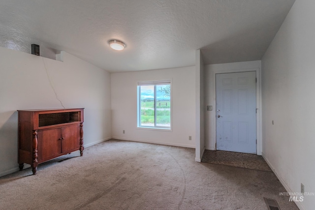 3537 Brogan Rd, Emmett, ID 83617 - unfurnished living room featuring carpet floors, baseboards, and a textured ceiling