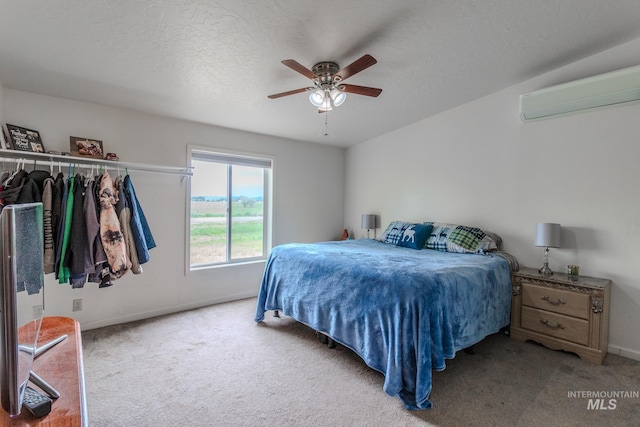 3537 Brogan Rd, Emmett, ID 83617 - bedroom with a wall unit AC, carpet floors, baseboards, a textured ceiling, and ceiling fan