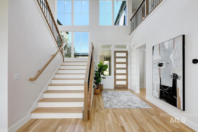 entryway with a towering ceiling and hardwood / wood-style flooring