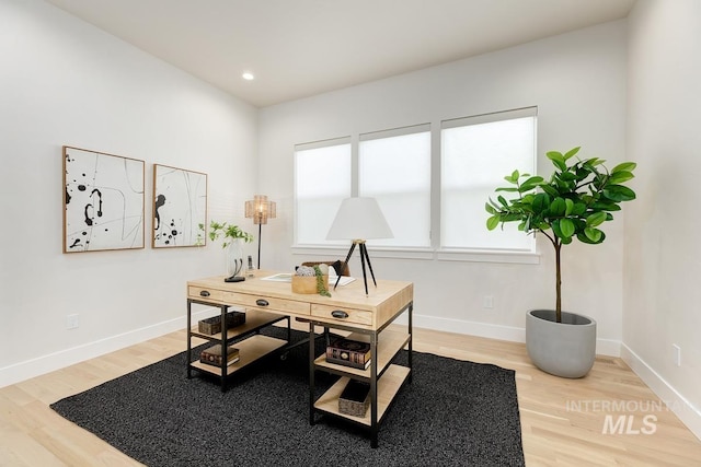 office with hardwood / wood-style flooring and a healthy amount of sunlight