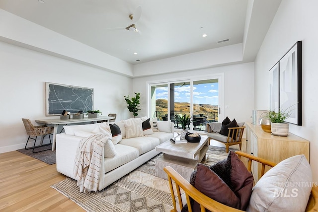 living room featuring light wood-type flooring and ceiling fan