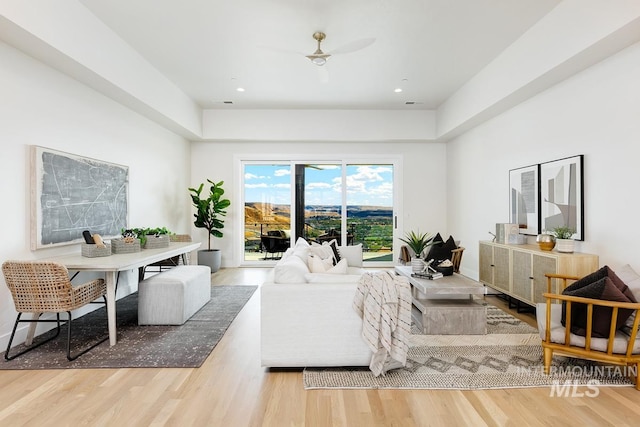 living room featuring ceiling fan and hardwood / wood-style flooring