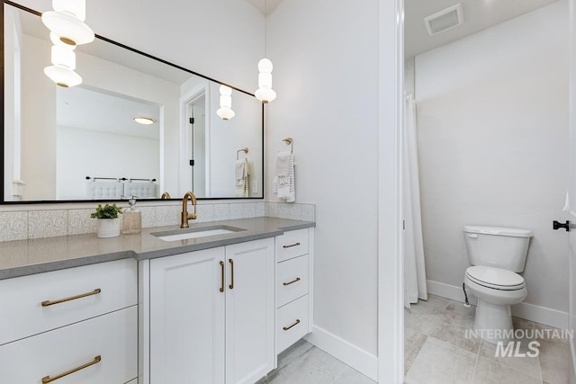 bathroom featuring vanity, tile patterned flooring, and toilet