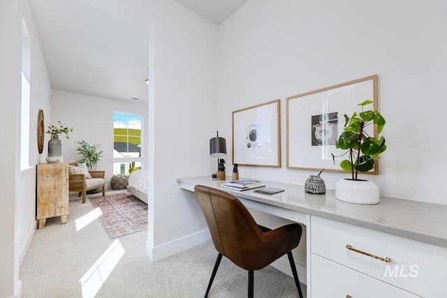 office area with built in desk and light carpet