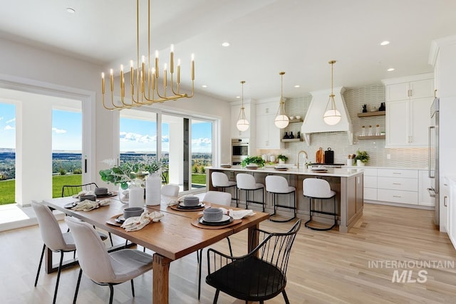 dining space with light hardwood / wood-style flooring, a chandelier, and a wealth of natural light