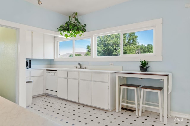 1406 Libby St, Clarkston, WA 99403 - kitchen featuring white dishwasher, light countertops, white cabinets, and a sink