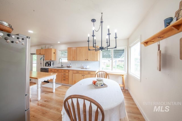 3509 8th St Unit C, Lewiston, ID 83501 - kitchen featuring light brown cabinets, freestanding refrigerator, a sink, a chandelier, and decorative backsplash