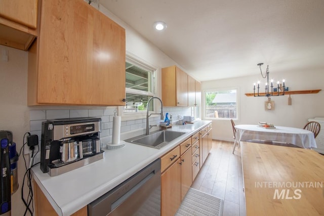 3509 8th St Unit C, Lewiston, ID 83501 - kitchen featuring stainless steel dishwasher, a sink, tasteful backsplash, light wood-style flooring, and a chandelier