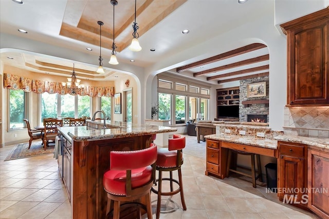 215 W Riverbridge Ln, Eagle, ID 83616 - kitchen with a raised ceiling, open floor plan, light stone counters, light tile patterned floors, and beam ceiling