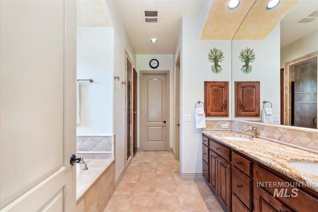 215 W Riverbridge Ln, Eagle, ID 83616 - bathroom featuring double vanity, a shower stall, a garden tub, backsplash, and recessed lighting