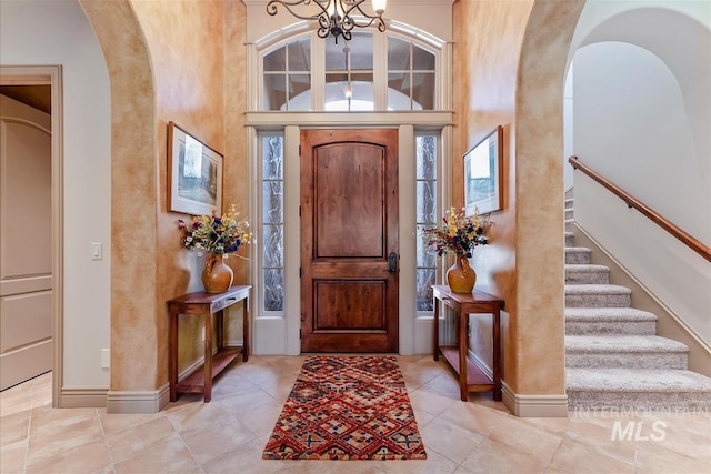 215 W Riverbridge Ln, Eagle, ID 83616 - tiled entrance foyer featuring arched walkways, a chandelier, and stairs