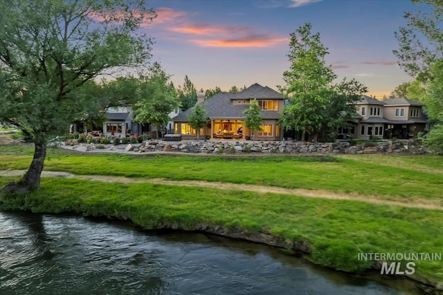 215 W Riverbridge Ln, Eagle, ID 83616 - rear view of property with a chimney, a water view, and a lawn